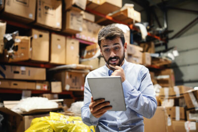 Man looking confused in warehouse with chaos around him