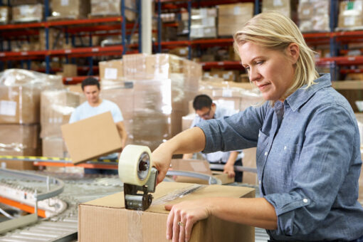 Woman packaging up a box in a warehouse