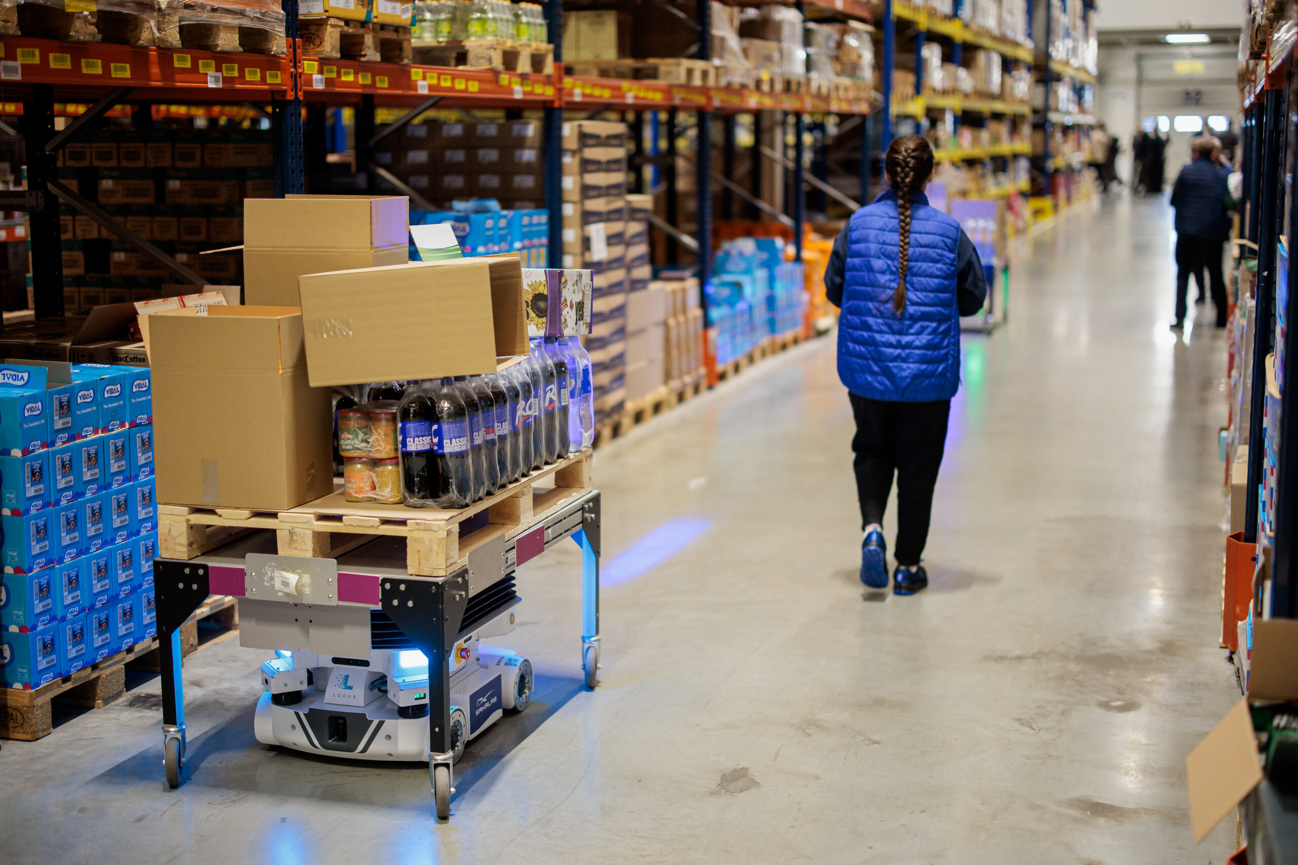 Vector in customer warehouse for picking with people in the aisle