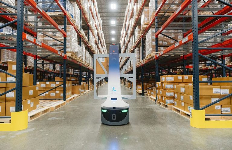Eversana-branded LocusBot in a warehouse aisle between tall racking stacked with pallets of cardboard cases