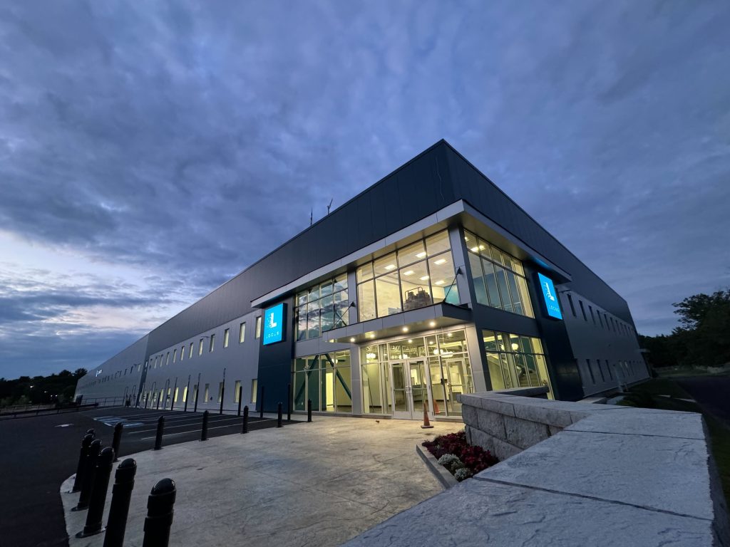 Locus Robotics headquarters building with illuminated Locus logo signs at dusk