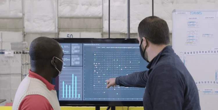 Locus Robotics team reviewing live warehouse performance data on a LocusONE dashboard