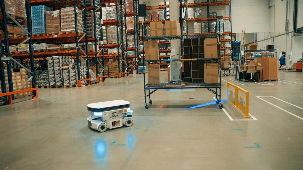 Locus Vector moving through the Sakalas warehouse between racking of packaged food